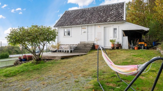 Uthuset på tomten har opparbeidet treterrasse og skifertak i samme stil som hovedhuset.