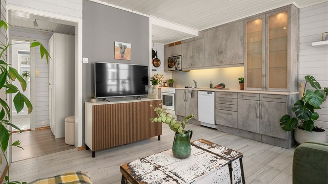 Kjøkkenet ligger naturlig tilbaketrukket fra stuen og er innredet med lyse slette flater, benkeplate av laminat og fliser mellom kjøkkenbenk og overskap.