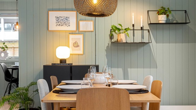 De malte panelveggene skaper en lun og innbydende ramme rundt spiseplassen.