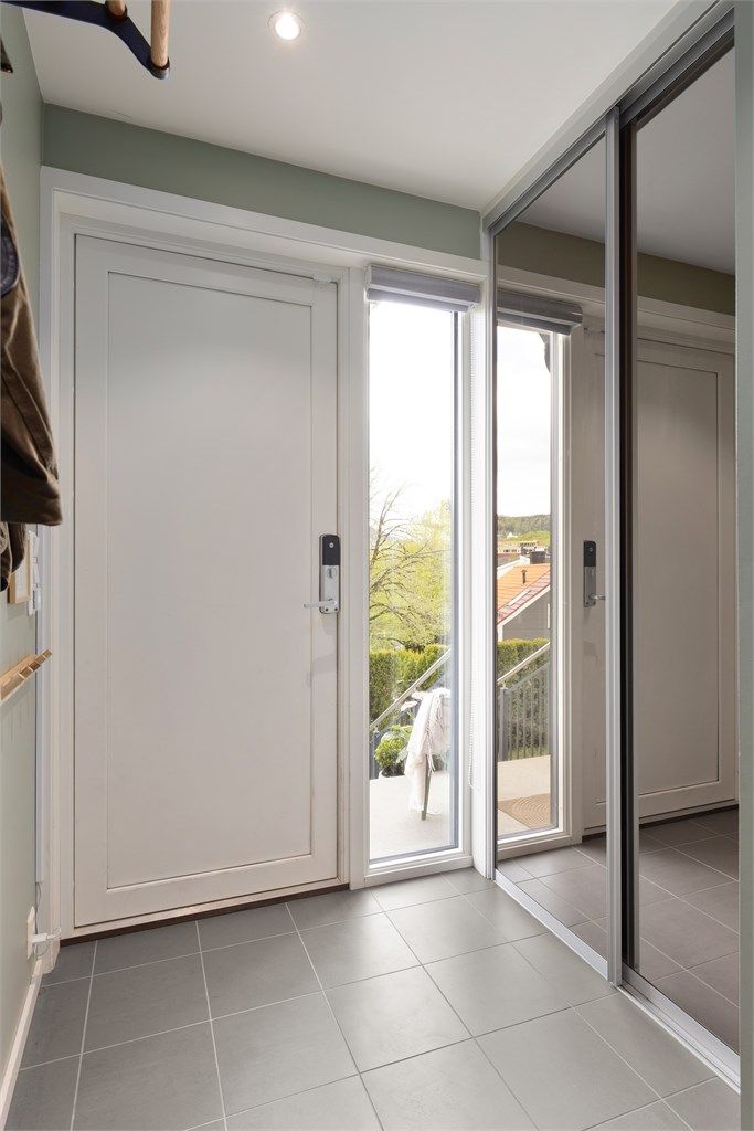 Entré med god plass til å henge fra seg yttertøy i skyvedørsgarderobe. Vindu ved siden av inngangsdører gir ekstra lys til rommet