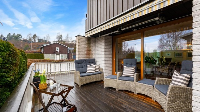 En skjermet og privat uteplass med god plass til en loungegruppe.