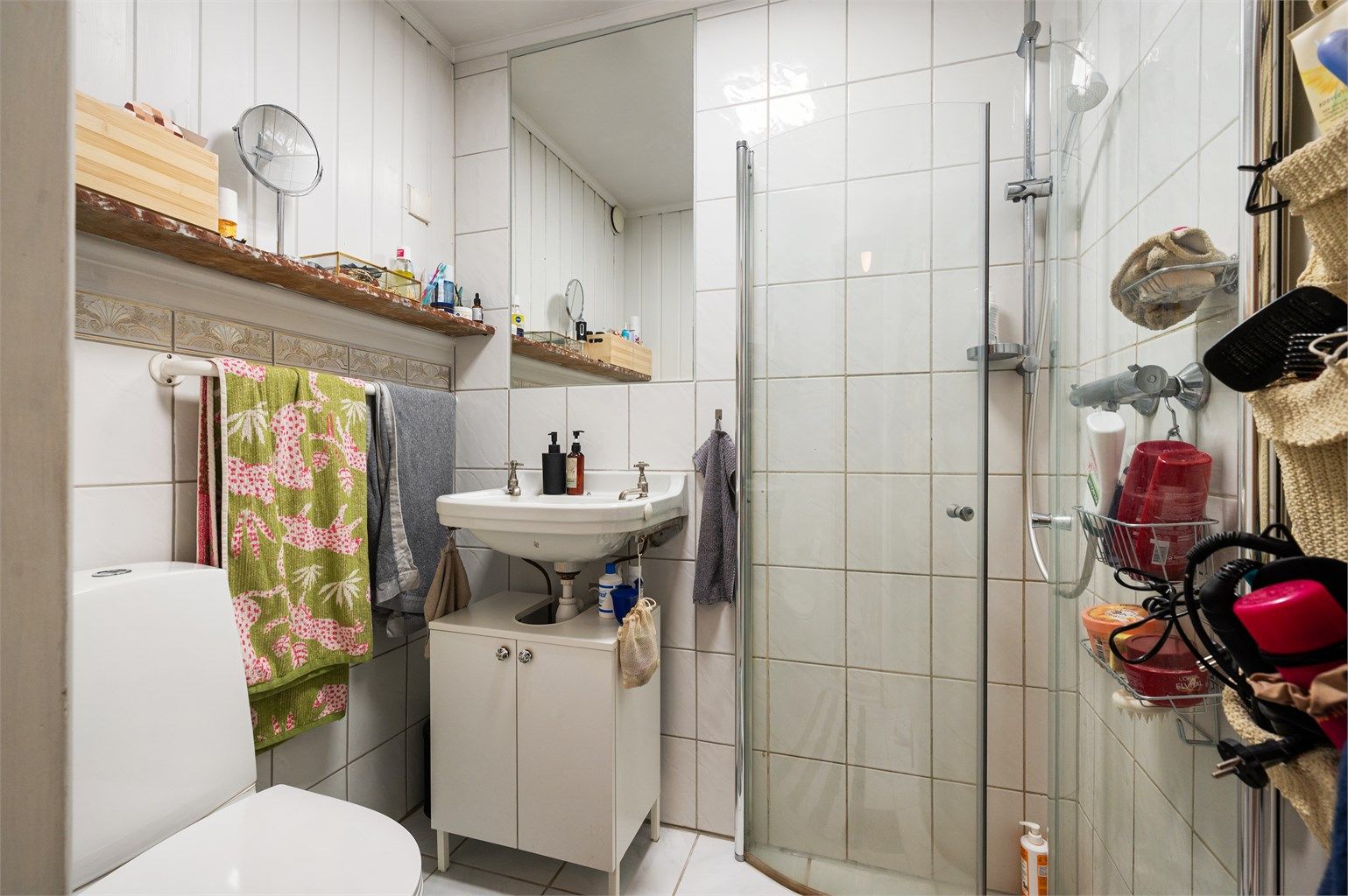 Baderommet er flislagt med varmekabler i gulv og er innredet med frittstående toalett, servant med ovenpåliggende vask og dusjsone med innfellbare dører i glass som er tilkoblet hånddusj. Det er gitt TG3 på badet.