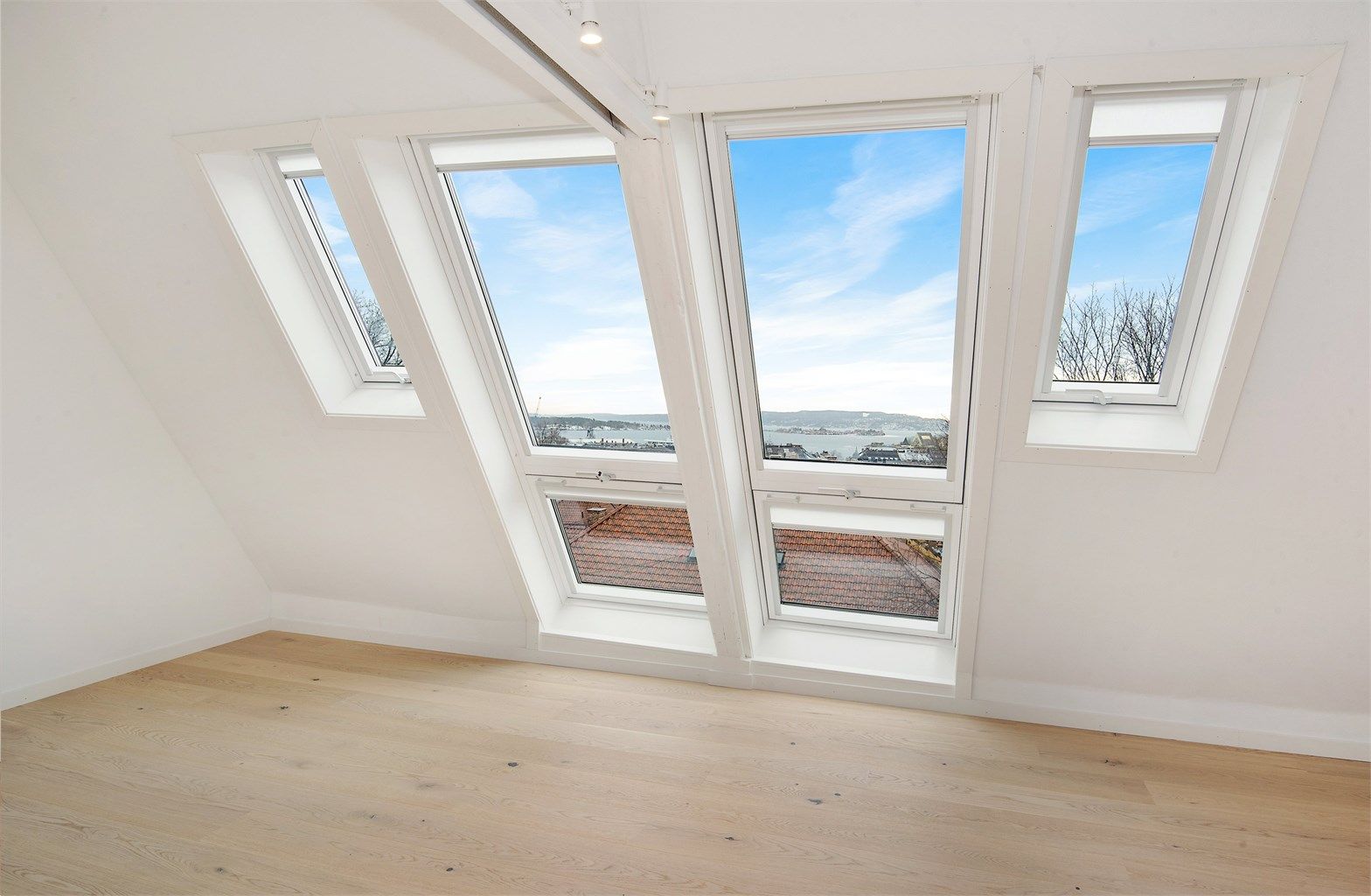 Loftstue med smarte balkongvinduer og panoramautsikt over indre Oslofjord.