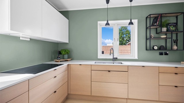 Kjøkkenet er like praktisk som det er elegant, med rikelig oppbevaringsplass og store arbeidsflater som gir optimale forhold for matlaging og sosialt samvær.