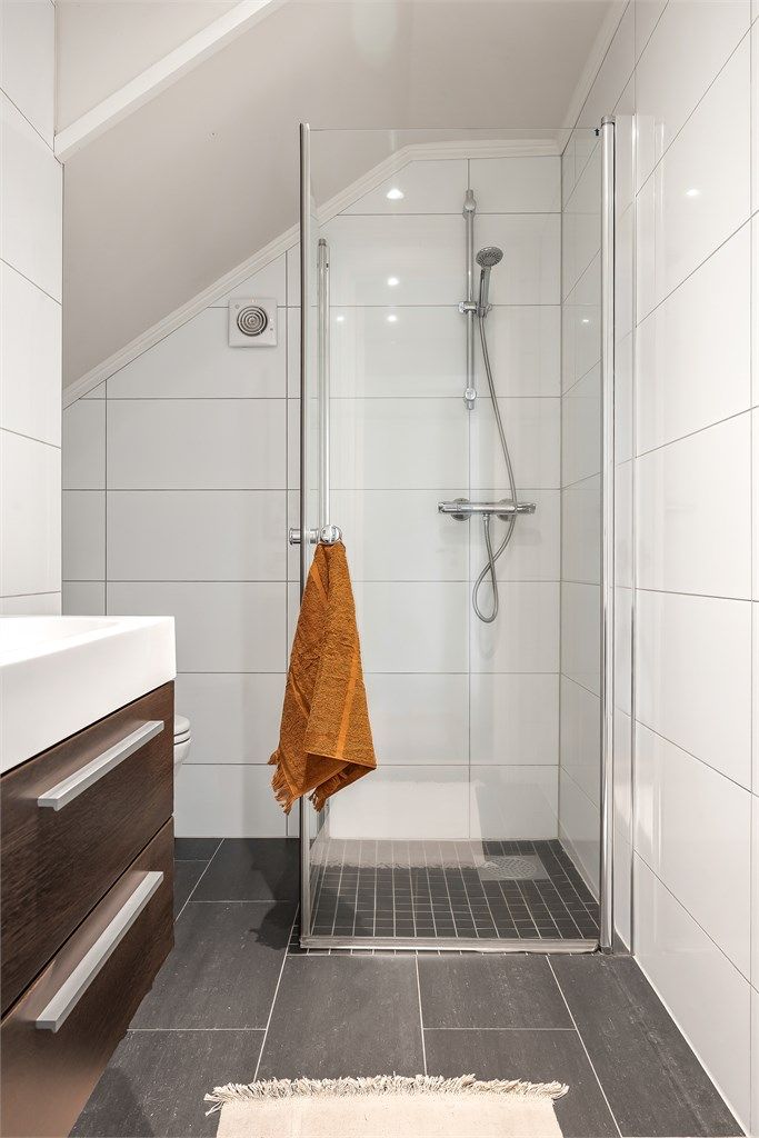 Badet har dusjhjørne med foldedører av glass.