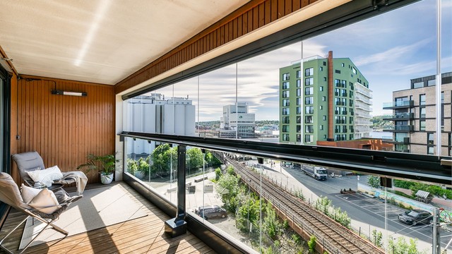 I den luftige høyden av femte etasje er det også gode solforhold.
Skjermende glass utvider verandaens bruksmuligheter og kan enkelt trekkes frem/tilbake.