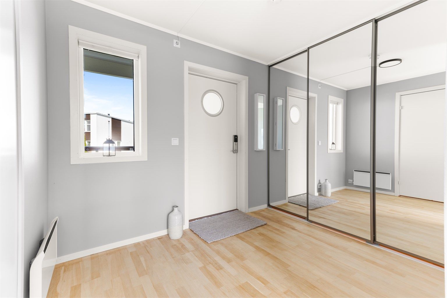 Velkommen inn i en lys entré med skyvedørsgarderobe