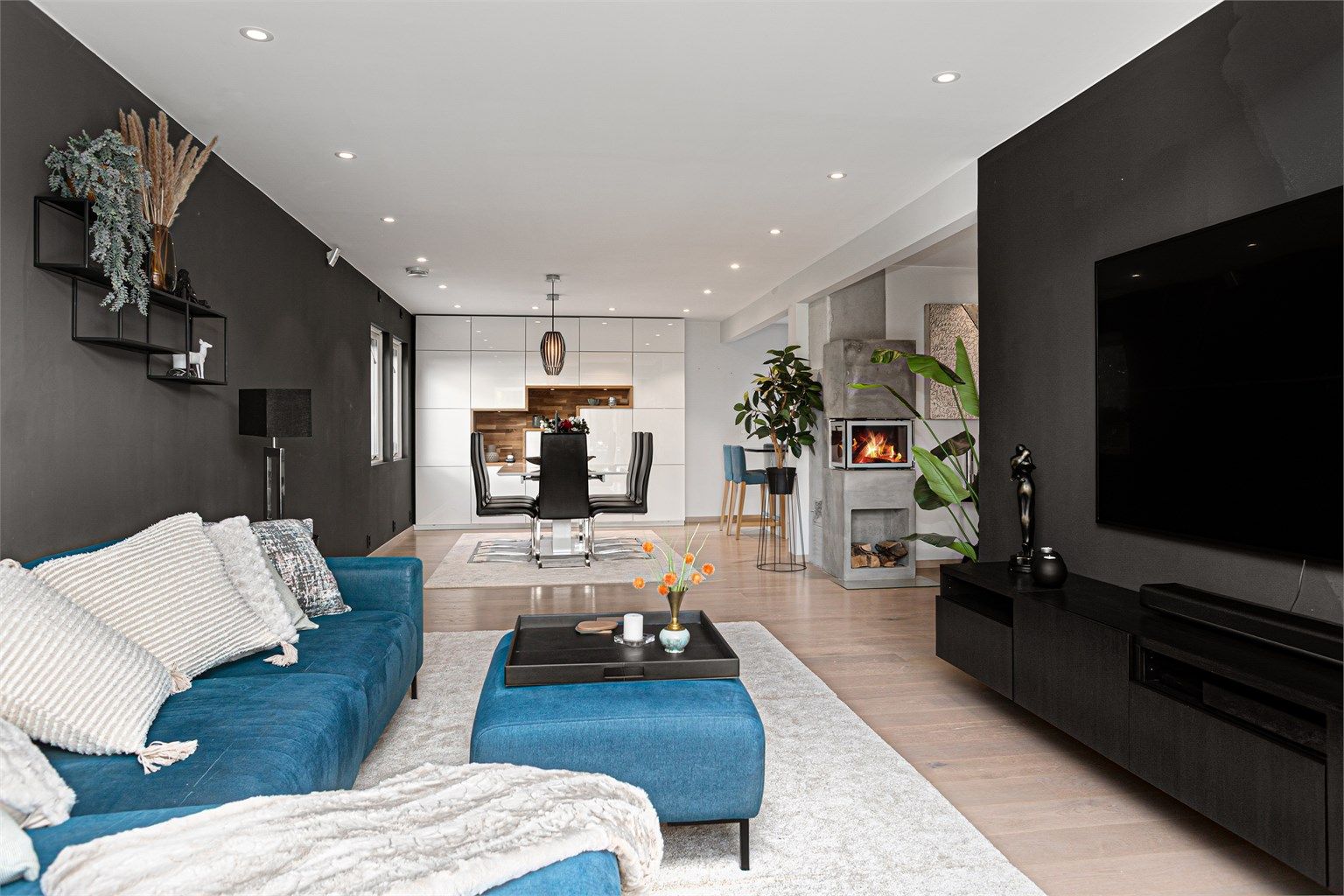 Åpen planløsning mot spisestue med koselig peisovn