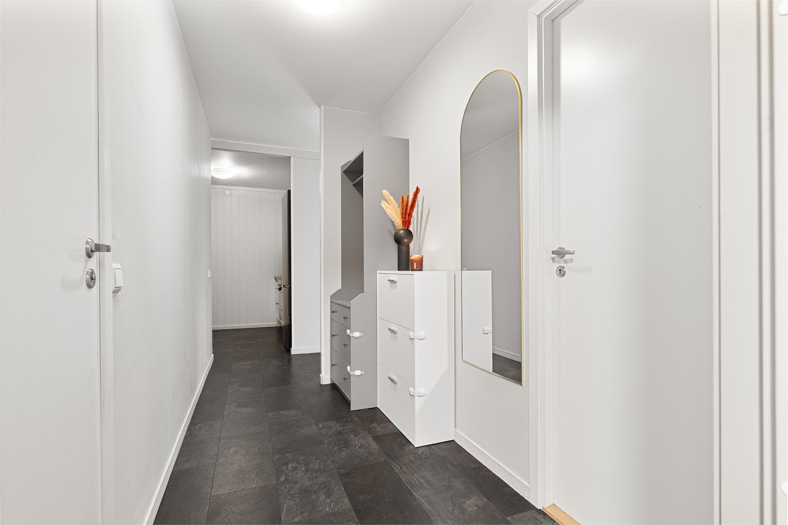 Velkommen inn! Romslig entré med god plass til oppbevaring av yttertøy og sko. Leiligheten disponerer også fire boder på til sammen 20 kvm med ytterligere lagringsmuligheter.