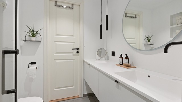 Lekkert baderom fra 2020 med gulvvarme og downlights. Det runde speilet har innebygd belysning. Godt med oppbevaring i benkeskap og integrerte hyllesystemer