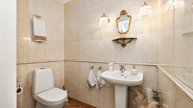 I tillegg til badet har leiligheten et praktisk, separat toalettrom med flislagte vegger.
