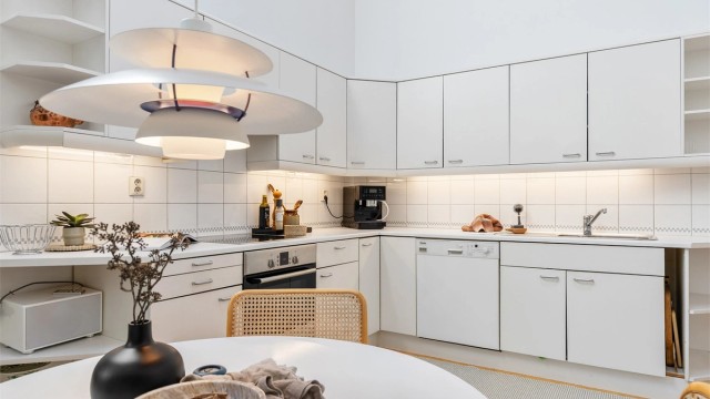 Norema kjøkkeninnredning fra byggeår med glatte fronter og benkeplate med laminert overflate. Kjøkkenvask med armatur og benkeskapsbelysning og stikkontakter over kjøkkenbenk. Integrert stekeovn og platetopp.