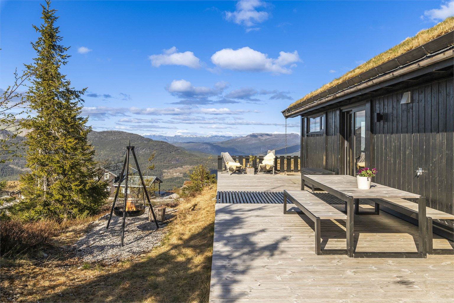 Den store terrassen på 136 m² omkranser hytta og har flere soner, inkludert en egen bålpanne for stemningsfulle kvelder.