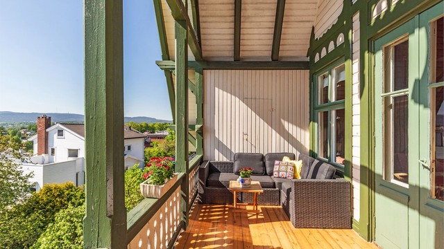 Verandaen i andre etasje er overbygd og har plass til sittegruppe. Det er bod på begge sider av verandaen