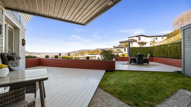 Den private uteplassen på totalt 94 kvm kombinerer treterrasse, hellelagt område og en lettstelt plen.