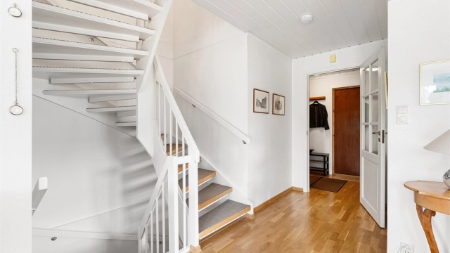 Trappen i trekonstruksjon binder de tre etasjene i boligen sammen.