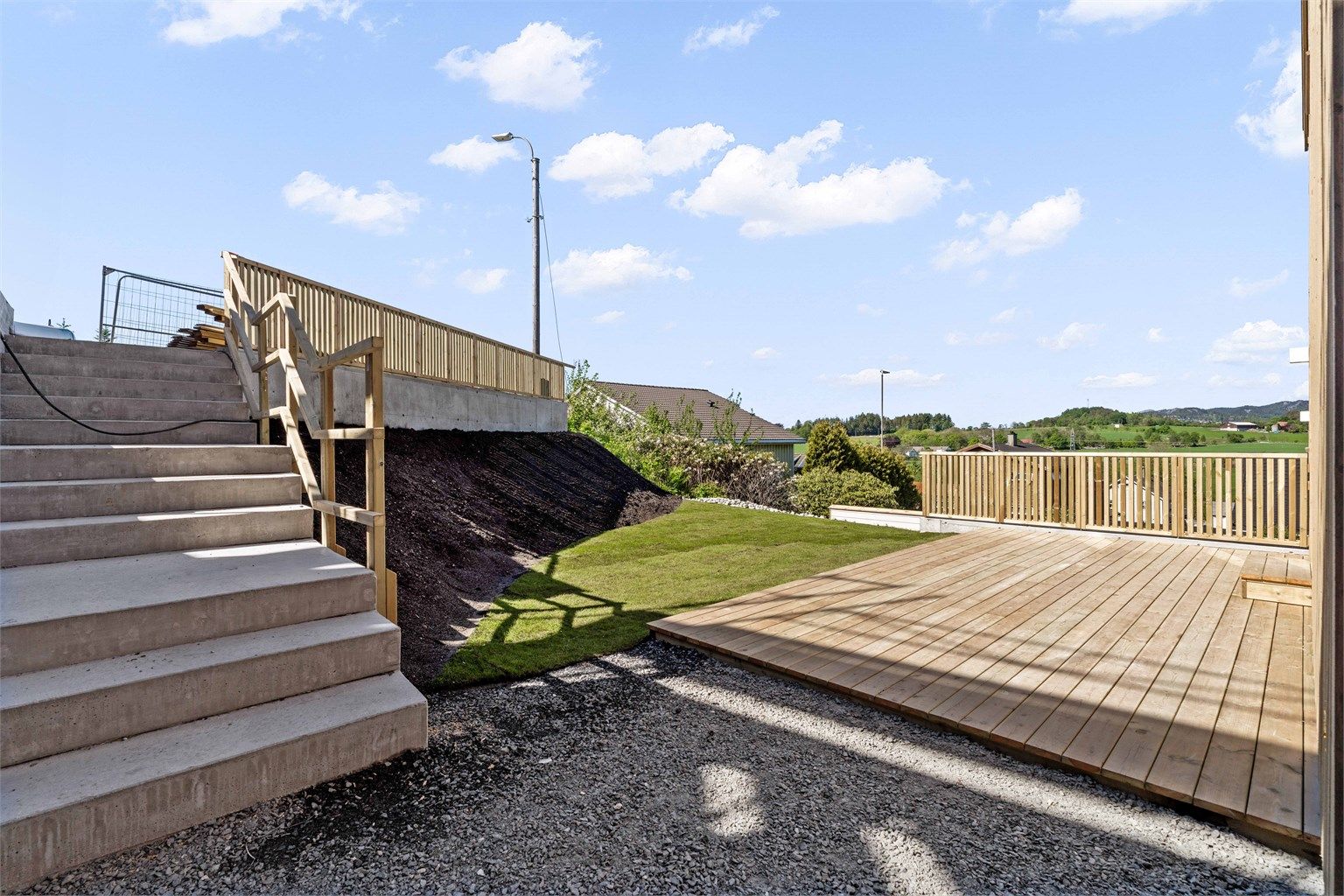 Uteplassen har et kjempe pent utsyn og 19 kvm terrasse gir plass til både grill og utemøbler.
Trappen går opp til boligens 2 biloppstillingsplasser ved veien (bak gjerdet)