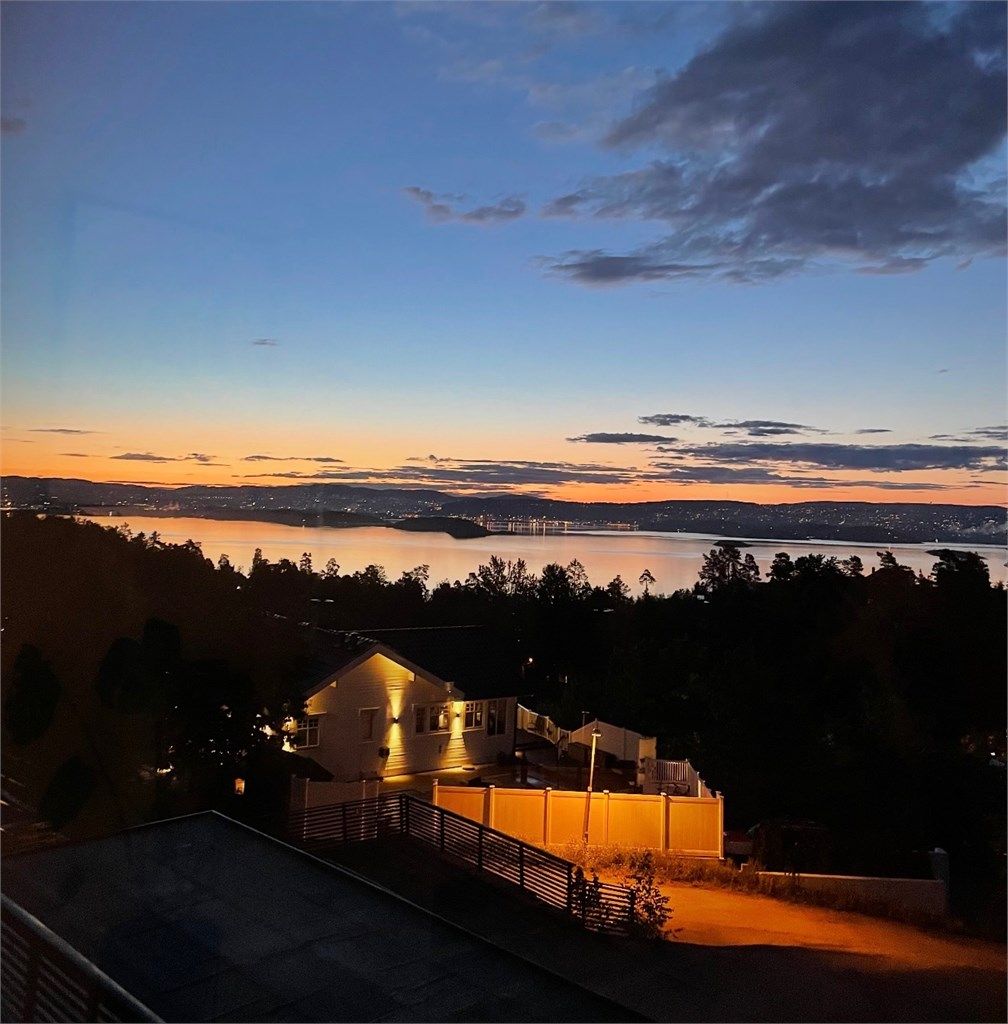 Himmelen fylles av magiske farger som glir over i et hav av bylys fra Oslo, som lyser opp horisonten når kvelden faller på.