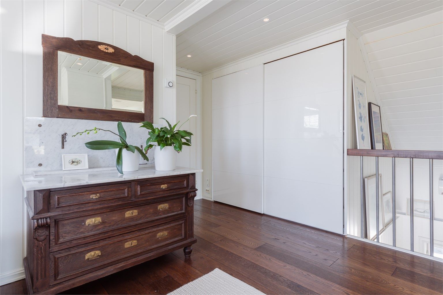 Praktisk lagringsplass i skyvedørsgarderobe som utnytter plassen under skråtaket.