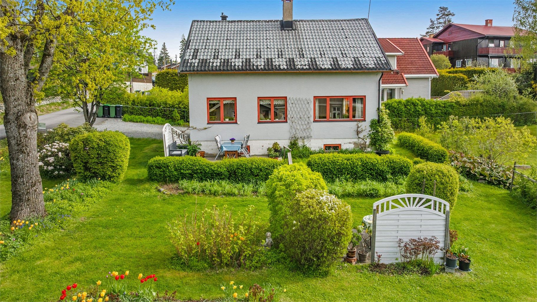 Huset har en pusset fasade og tak tekket med stål- eller aluminiumsplater.