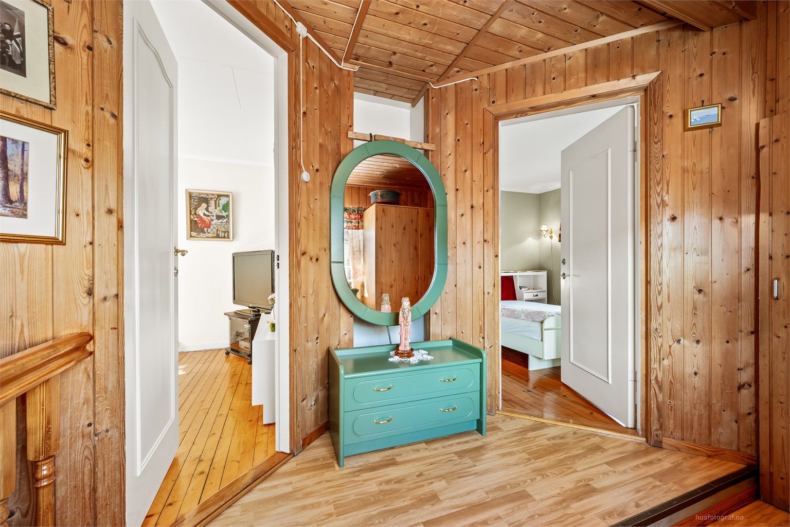 Her oppe er det overflater med panel og laminatgulv, og profilerte innerdører.