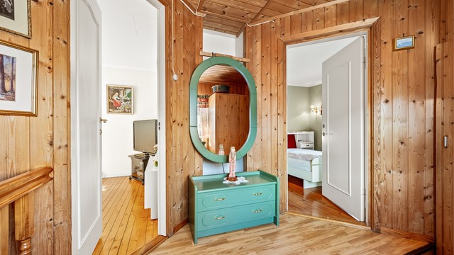 Her oppe er det overflater med panel og laminatgulv, og profilerte innerdører.