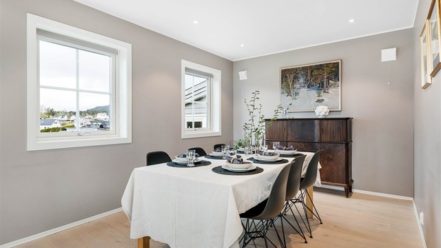 Egen sone i stuen med god plass til å kunne dekke langbord. Det er lagt til rette med spikerslag i hele endeveggen dersom ny eier ønsker TV på veggen.