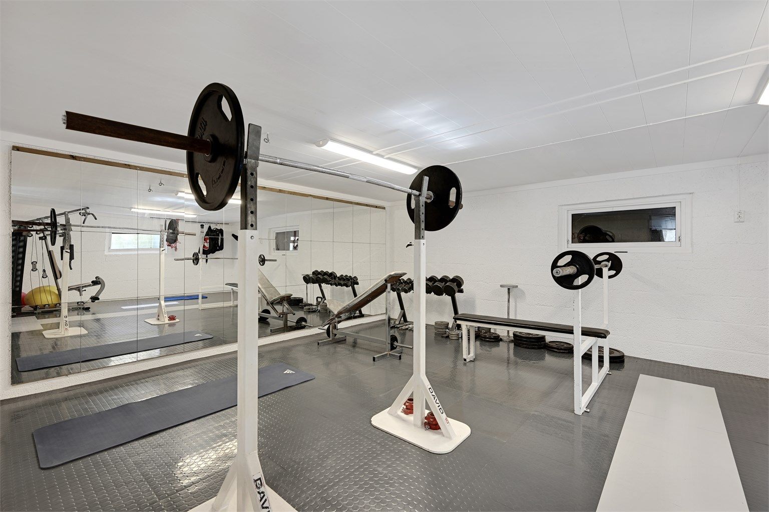 I kjelleren på det største garasjebygget er det innredet et fullverdig treningsrom med vannbåren gulvvarme. (Ikke godkjent til varig opphold).