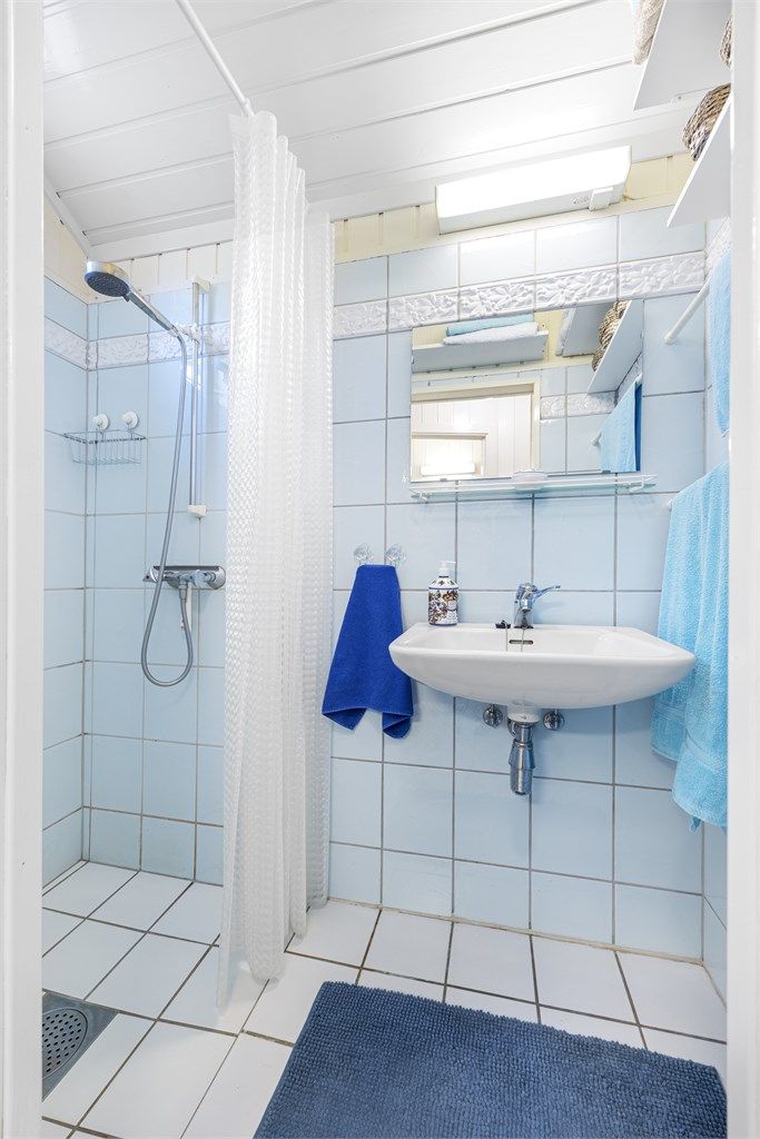 Badet i hovedetasjen har flislagt gulv med varmekabler og fliser i dusjsonen.