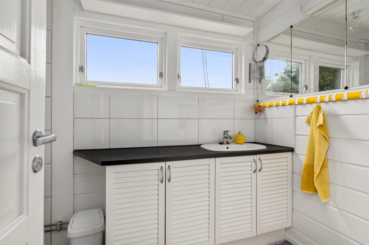 Bad med dusj og servant i seksjon.