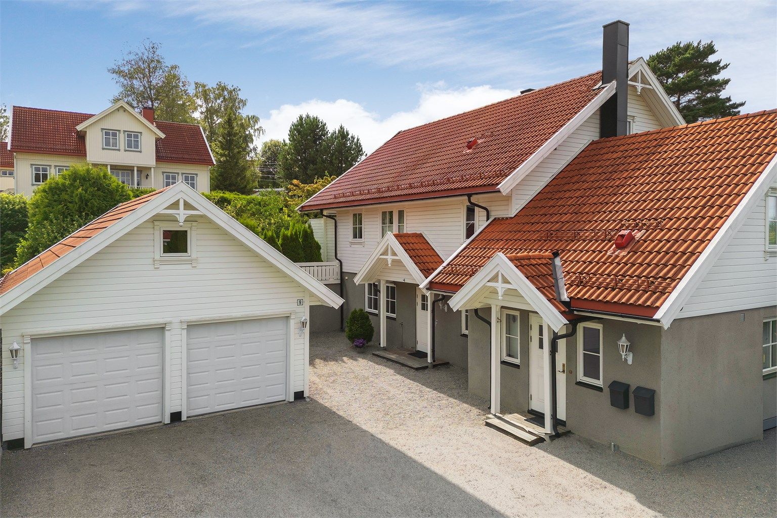 Gruslagt gårdsplass og frittstående dobbelgarasje med to leddporter, samt lagringsplass.