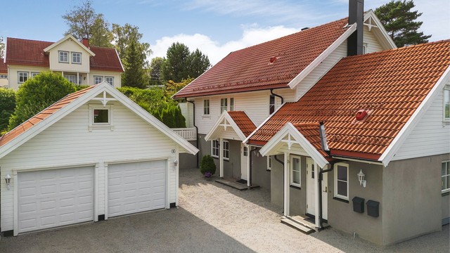 Gruslagt gårdsplass og frittstående dobbelgarasje med to leddporter, samt lagringsplass.