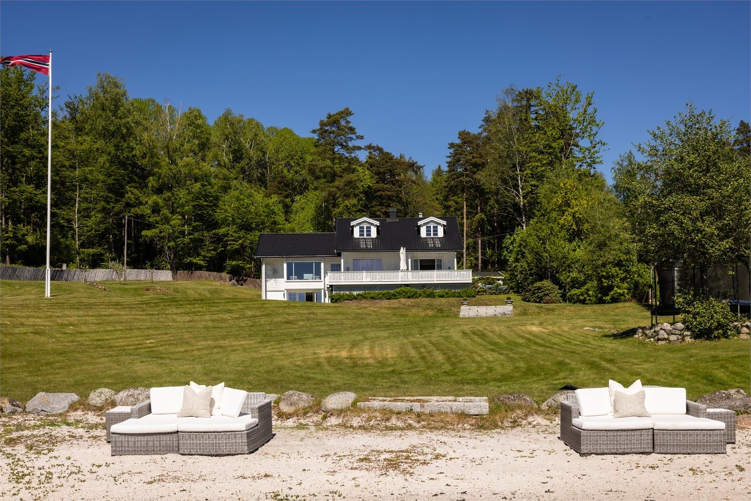 Utsikt fra stranden opp mot hovedhuset.