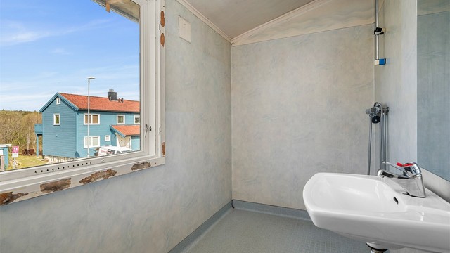 Badet måler 3,5 kvm og har enkel utførelse med servant og vegghengt dusjarmatur. Oppgradering i henhold til dagens standard må påregnes.
