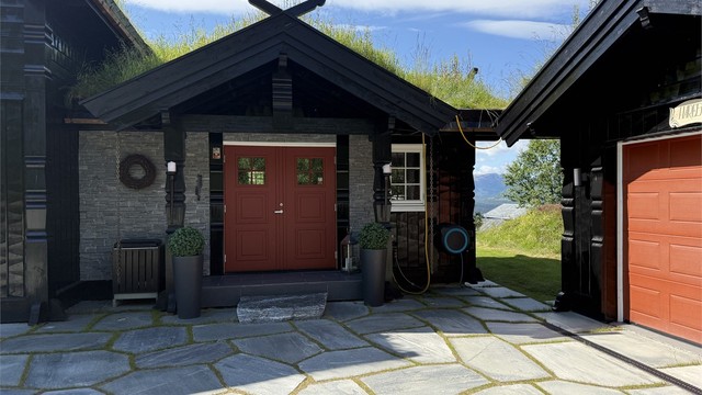 Fra den skiferbelagte gårdsplassen er det kort vei til både hovedinngang og garasje.