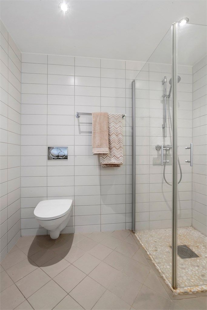 Badet er utstyrt med vegghengt toalett med innebygget sisterne.