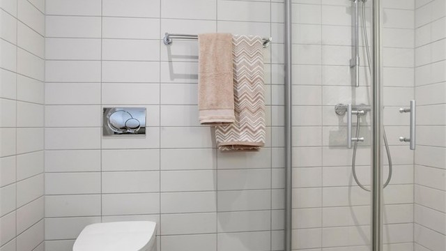 Badet er utstyrt med vegghengt toalett med innebygget sisterne.
