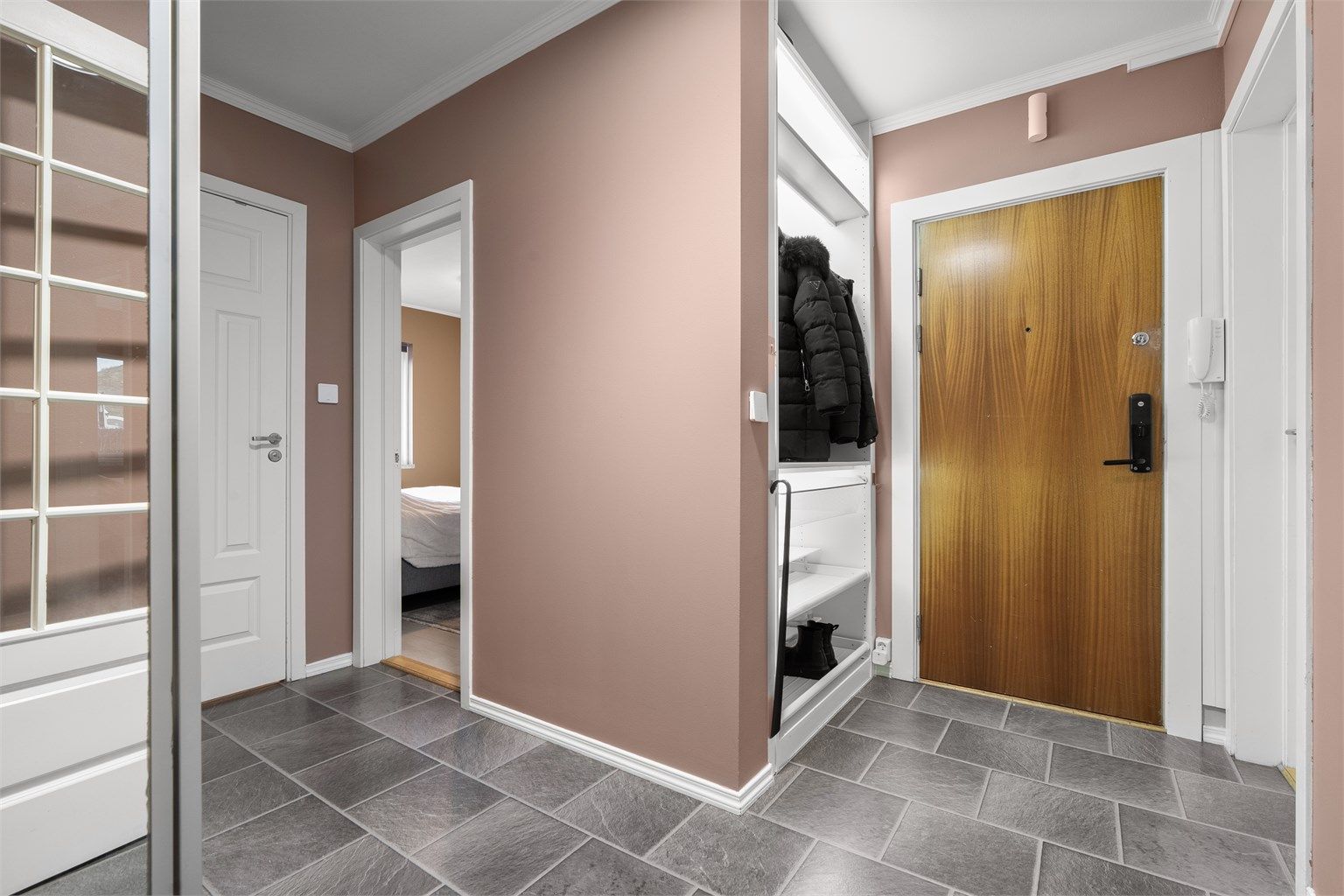 Leiligheten ligger i en høy 1. etasje, med adkomst via en innbydende entré.