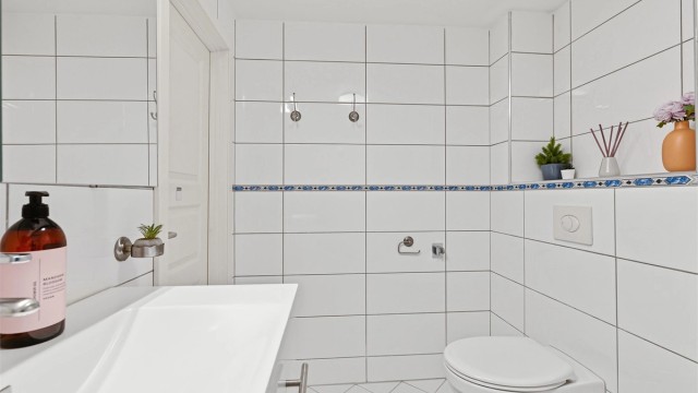Romslig flislagt bad med varmekabler for lun varme mot nakne føtter. Badet ligger i 2 etg.