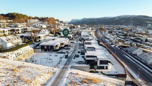 Dronebilde av boligområdet tatt fra vest mot øst - stor lekeplass like vest for boligen.