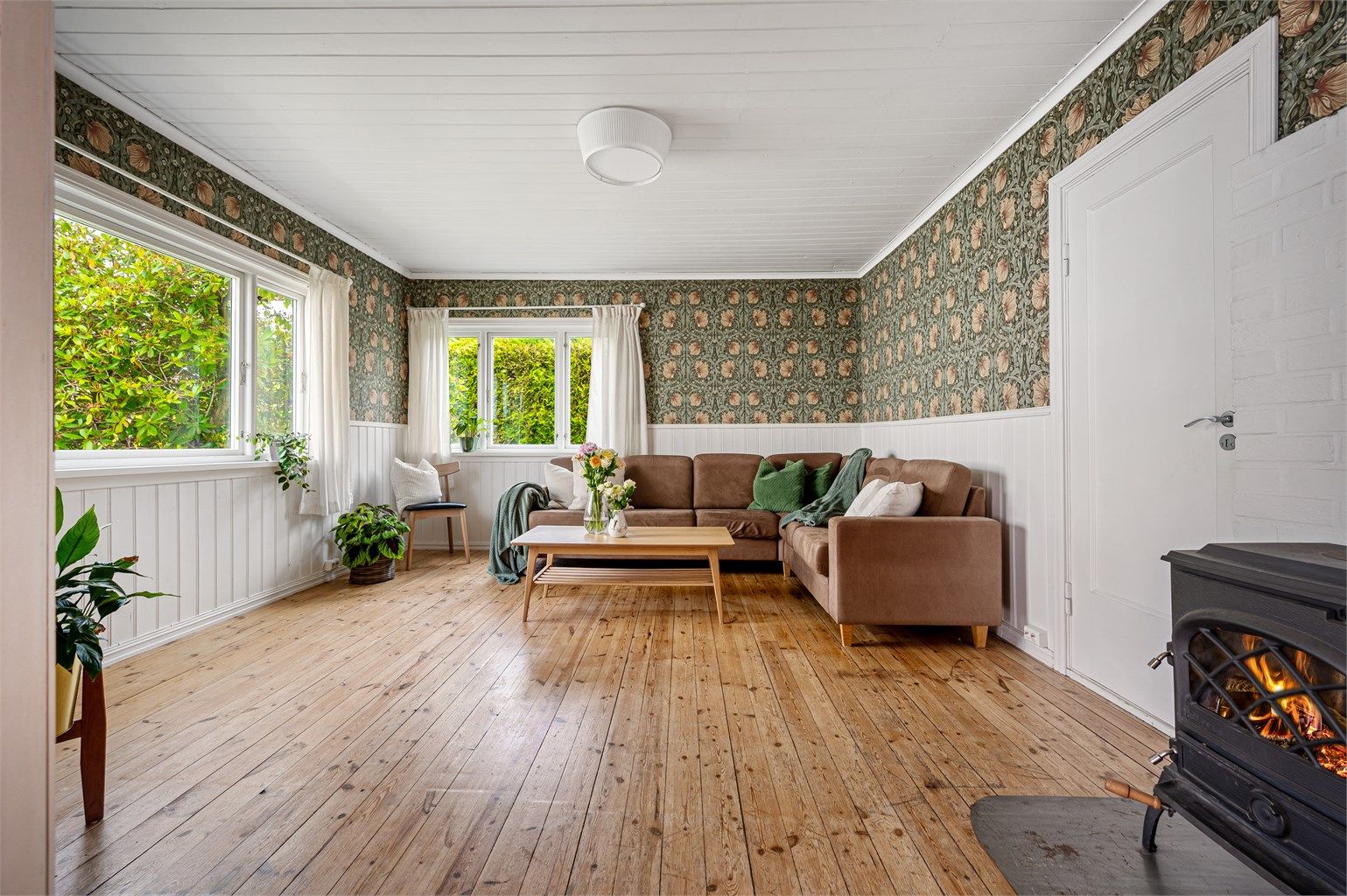 Originale tregulv i stue og soverom, sjarmerende tapet som hever interiøret og skaper harmoniske kontraster.