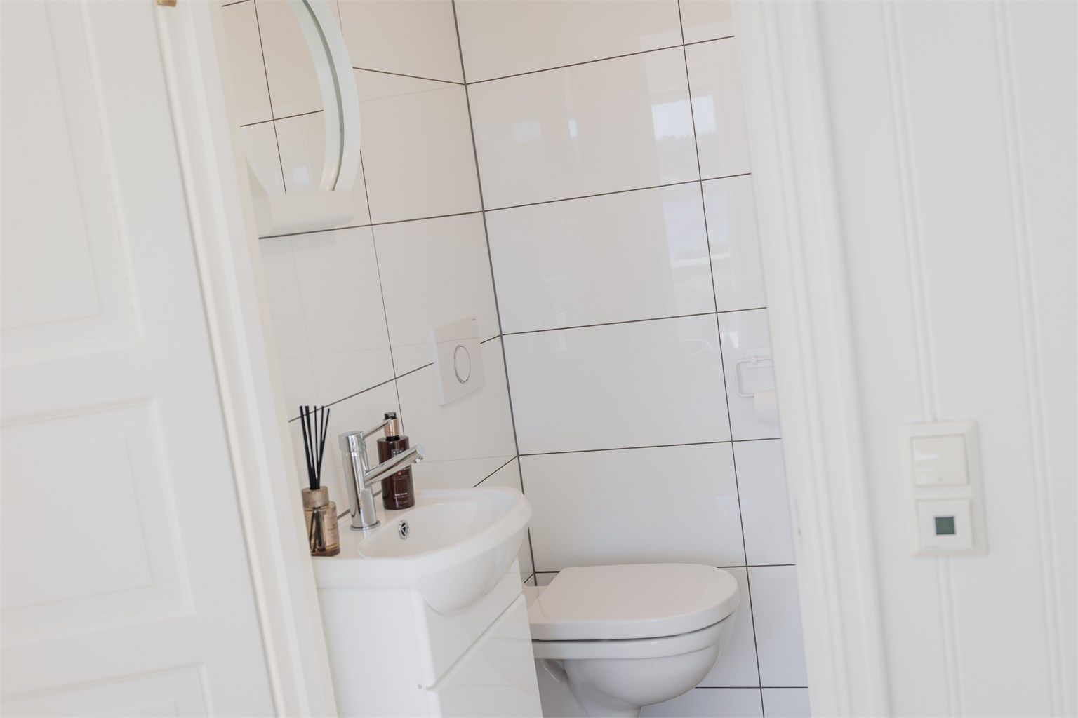Badet er utstyrt med vegghengt toalett og servant.