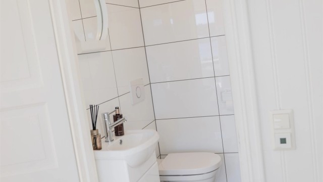 Badet er utstyrt med vegghengt toalett og servant.