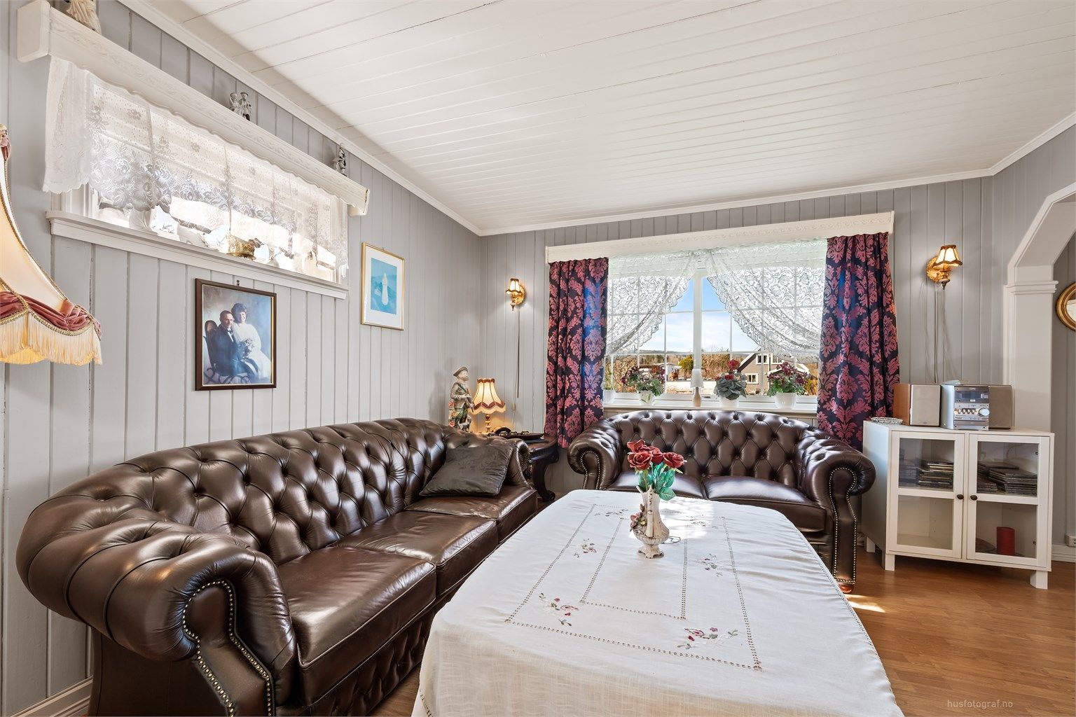 Rommet har vegger og himling med malt panel, som gir en klassisk og varig karakter.