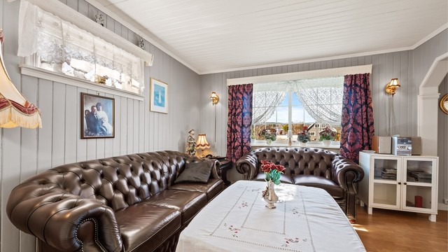 Rommet har vegger og himling med malt panel, som gir en klassisk og varig karakter.