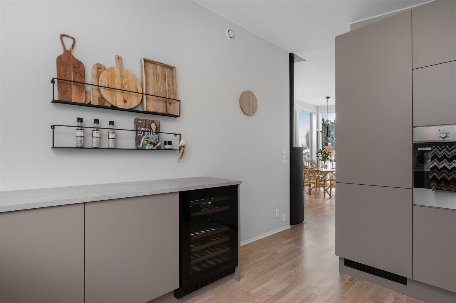 Videre er kjøkkenet utstyrt med integrerte hvitevarer som vinskap, stekeovn, platetopp, oppvaskmaskin og kjøleskap med fryser.