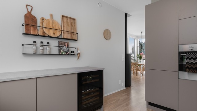 Videre er kjøkkenet utstyrt med integrerte hvitevarer som vinskap, stekeovn, platetopp, oppvaskmaskin og kjøleskap med fryser.