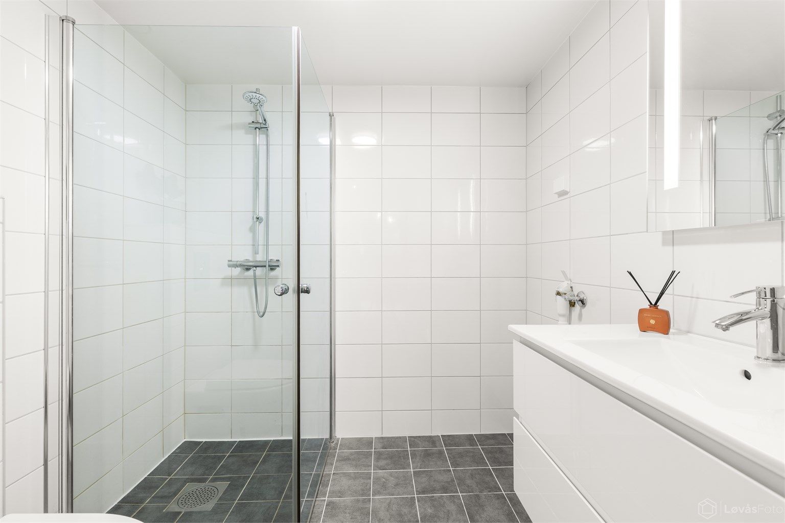 Badet i kjelleren har flislagt gulv med gulvvarme, dusjnisje og vegghengt toalett.