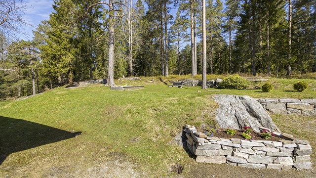 Tomten er pent opparbeidet med natursteinsmurer som skaper fine overganger i terrenget.