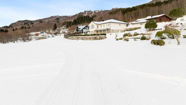 Uteområdet består av store plenarealer som enkelt vedlikeholdes med robotgressklipper.